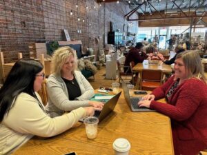 women working on their laptops at a coffee shop